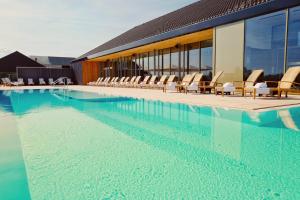 多瑙艾辛根Der Öschberghof Golf Resort des Jahres 2024的一座带椅子的大型游泳池和一座建筑