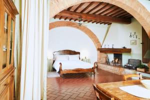蒙特普齐亚诺阿格里图里斯莫马兹农家乐的一间卧室配有一张床和一个壁炉