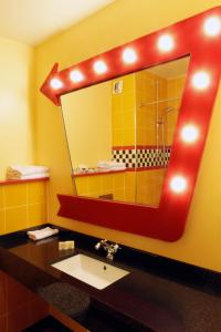 考普瓦利Disney Hotel Santa Fe的浴室设有水槽和带淋浴的镜子。