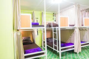 大城Plus Hostel Ayutthaya的客房设有三张双层床和紫色床单