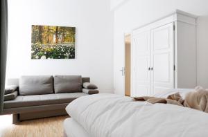 柏林SC 2 Cozy Family & Business Flair welcomes you - Rockchair Apartments的白色卧室配有床和沙发