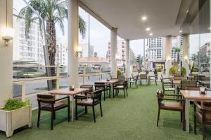 托雷洪-德阿尔多斯托雷洪埃塞特酒店的一间设有桌椅的餐厅,种植了棕榈树