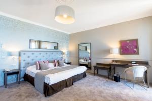 尼斯昂格鲁大道皇家酒店的酒店客房设有一张大床和一张书桌。
