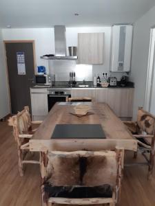 丰罗穆Le Grizzly Luxe Location的厨房配有带椅子的木桌
