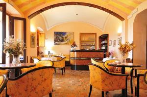 卡拉·利贝罗托Hotel Villa Campana的一间在房间内配有桌椅的餐厅