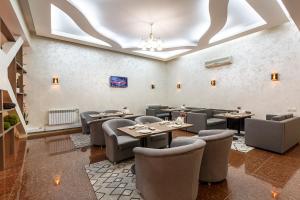 阿拉木图若尼欧尼酒店的一间在房间内配有桌椅的餐厅