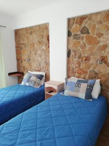 奥德赛克斯Sol Mar的石墙客房中的两张蓝色的床