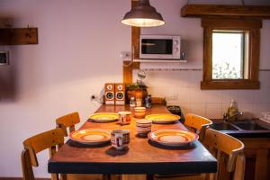 厄尔查尔坦Inlandsis Aparts的厨房里一张木桌,上面有盘子和杯子