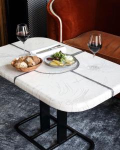 巴黎勒斯班斯巴黎酒店的一张桌子,上面放着一盘食物和两杯葡萄酒