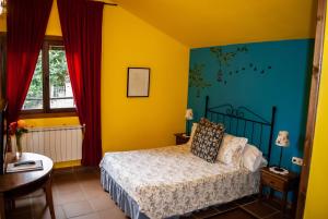 Almiruete厄尔维托尔德尔阿布罗卡萨乡间Spa旅馆的一间卧室设有一张黄色和蓝色墙壁的床