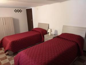 巴勒莫I babbaluci的卧室内的两张床,配有红色棉被