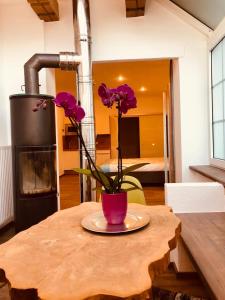 圣吉尔根Echt Heimat Apartments的一张桌子,上面有花瓶,上面有紫色的花