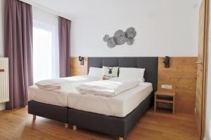 米明Seelos - Alpine Easy Stay - Bed & Breakfast的一间卧室配有一张带白色床单的大床