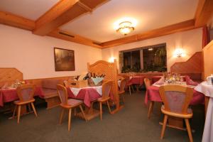 TauplitzalmHotel Alpenrose的餐厅配有桌椅和红色桌布