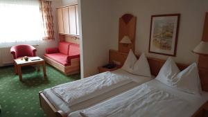 TauplitzalmHotel Alpenrose的配有一张床和一把椅子的酒店客房
