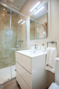 塞维利亚Lukanda Mariana的白色的浴室设有水槽和淋浴。