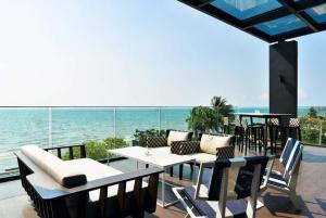 纳仲天Veranda Residence Pattaya x Sea & Sky View的一个带桌椅的庭院和大海