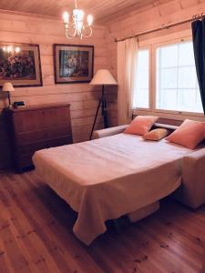 凯里迈基Big Cottage By The Lake的木制客房内的一间卧室配有一张大床