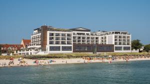 沙博伊茨海湾酒店的海滩上一座大型建筑,上面有人