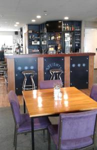 OwakaCatlins Inn的一间带木桌和紫色椅子的用餐室