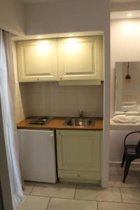 纳克索乔拉瓦西利科斯公寓式酒店的小厨房配有白色橱柜和水槽