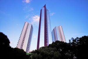 瓜达拉哈拉Hard Rock Hotel Guadalajara的一座城市里三座高楼,有一座摩天大楼