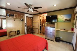 奥欣赛德Kaza Kokos的一间卧室配有红色的床和一台平面电视