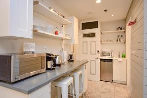 惠斯勒Newly Renovated Whistler Studio的厨房配有白色橱柜和台面