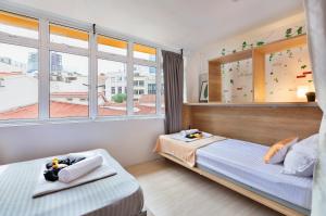 新加坡hipstercity hostel的一间卧室设有两张床和窗户。