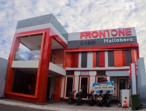 日惹Front One Cabin Malioboro Jogja的外面停有摩托车的红白加油站