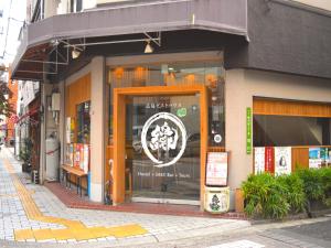 广岛广岛EN旅舍的街道窗户上带有标志的商店