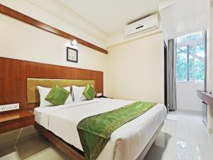 班加罗尔Treebo Trend Akshaya Bull Temple的一间卧室设有一张大床和一个窗户。