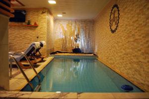 伊兹密尔马莱特精品酒店的一个游泳池,一个在房间里工作的男人