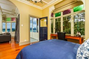 奥克兰Devonport Harbour View的卧室配有一张床、一张书桌和窗户。
