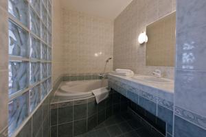 波杰布拉迪林哈特旅馆的带浴缸、水槽和镜子的浴室