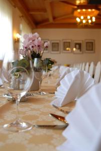 巴特圣莱昂哈德艾巴恩塔勒嘎斯霍夫餐厅酒店的长桌,带酒杯和鲜花