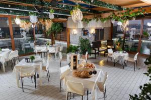 那不勒斯Hotel Residence Confalone的餐厅配有白色的桌椅和灯光