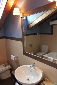 昆卡希拉尔多修道院酒店的一间带水槽、卫生间和镜子的浴室