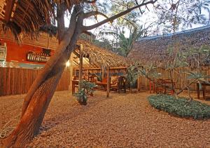 迭戈苏瓦雷斯Hotel Le Petit Paradis的餐厅设有稻草小屋,配有桌椅