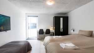 Við Gjógv吉雅加杜尔乔夫宾馆的一间卧室配有两张床、一张桌子和一台电视。