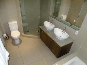 豪特湾Chapman's Peak Penthouse的一间带两个盥洗盆、淋浴和卫生间的浴室