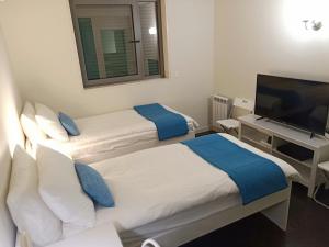 里斯本YingYing Apartamento with a free parking space的酒店客房设有两张床和一台平面电视。