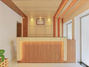 特里凡得琅Treebo Trend Goodland Residency的一间设有木镶板的房间和前台