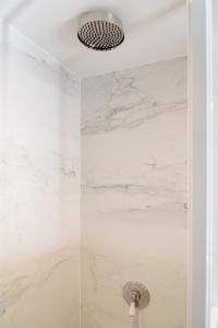 奥斯坦德奥斯坦德哥特维公寓的配有白色大理石墙壁和淋浴头的淋浴