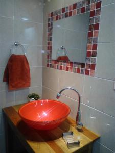 伊瓜苏港ZUHAUSE的一间带红色水槽和镜子的浴室