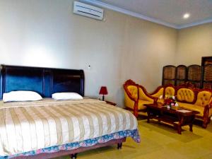 BaubauNirwana Buton Villa的卧室配有一张床和一张桌子及椅子