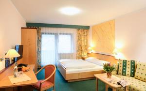MottenHotel Gasthof zum Biber的配有一张床和一张书桌的酒店客房