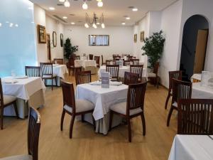 科尔多瓦Hotel Abadi的一间设有白色桌椅的用餐室