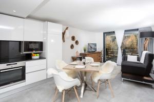 夏蒙尼-勃朗峰La Cordee 412 Apartment - Chamonix All Year的厨房以及带桌椅的用餐室。
