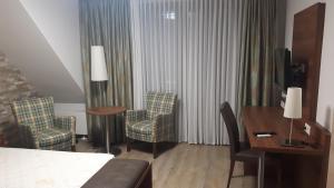 巴特罗森菲尔德德雷尔格尼酒店的酒店客房,配有一张床、一张桌子和椅子